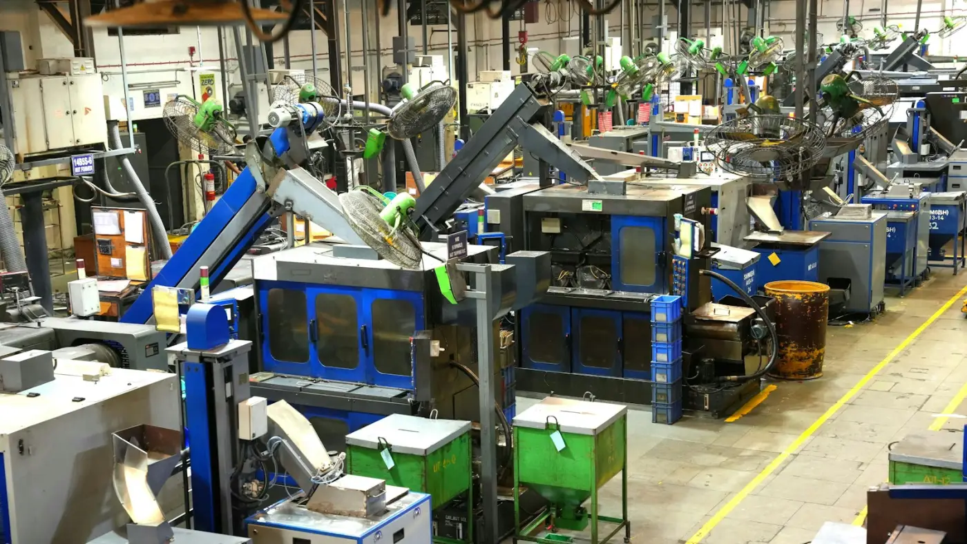 A factory floor with rows of machinery and yellow walkway markings